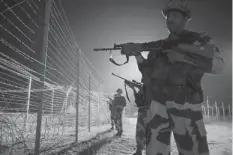  ?? AGENCE FRANCE PRESSE ?? Indian Border Security Force (BSF) soldiers patrol along the border fence at an outpost along the India-Pakistan border in Abdulian, 38 kms southwest of Jammu.