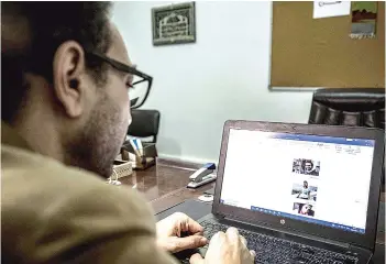  ?? — AFP photo ?? Mohamed Lotfy browses images of detained activists on his laptop in the capital Cairo.