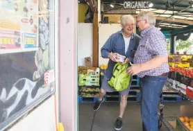  ?? Jessica Christian / The Chronicle ?? Steve Rasmussen (right), owner of Milk Pail Market, greets a customer. Rasmussen’s shop is near Facebook’s future office.