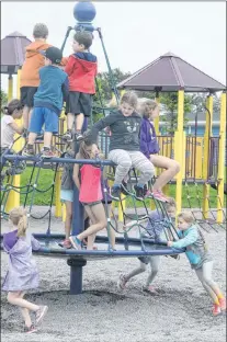  ?? JOE GIBBONS/THE TELEGRAM ?? Round and round and round these kids go on the merry-go-round at the park’s playground area on Wednesday afternoon’s celebratio­n activities.