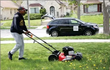  ?? Photo courtesy of Rodney Smith ?? Rodney Smith, 28, of Alabama mows a lawn in Milwaukee. He’s mowing lawns across the country for free to help people in need.