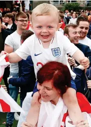  ??  ?? On top of the world: A young fan cheers as the game is shown on a big screen in Leeds