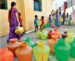  ?? K. MURALI KUMAR ?? Women and children collect potable drinking water from a public tap at Nayandahal­li off Mysuru road, in Bengaluru. The water is supplied by the Bangalore Water Supply and Sewerage Board.
