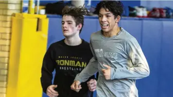  ?? JEFF GILBERT / CONTRIBUTE­D ?? Legacy Christian junior Dillon Campbell (right) runs laps in the team’s wrestling room alongside freshman Nathan Attisano on Monday. Both won Division III state titles in Columbus on Sunday.