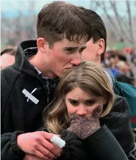  ?? Photograph: Bebeto Matthews/AP ?? In this 25 April 1999 photo, Austin Eubanks hugs his girlfriend during a memorial service for Columbine high school shooting victims.