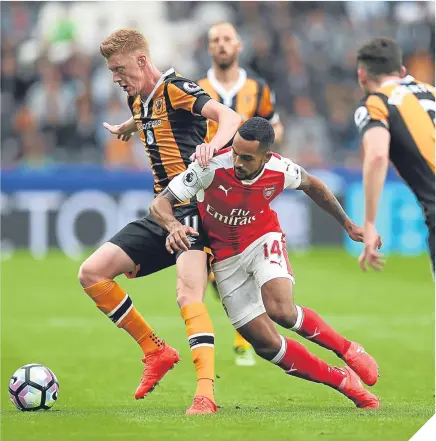  ??  ?? ■ Hull midfielder Sam Clucas attempts to keep Arsenal dangerman Theo Walcott at bay.