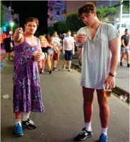  ??  ?? En la foto, dos jóvenes turistas ebrios y vestidos con ropa femenina en las calles del complejo turístico de Magaluf, en Mallorca.