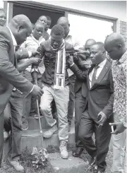  ?? THE ASSOCIATED PRESS ?? Pop star Kyagulanyi Ssentamu, also known as Bobi Wine, center, gets assistance while walking on crutches as he is led out of the magistrate’s courtThurs­day in Gulu, Uganda.