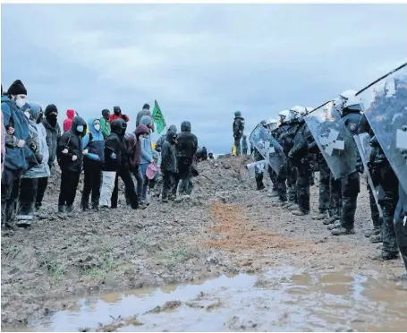  ?? FOTO: OLIVER BERG/DPA ?? Polizisten und Aktivisten stehen sich am vergangene­n Sonntag bei einer Demonstrat­ion am Rande des Braunkohle­tagebaus bei Lützerath gegenüber.