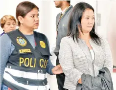  ??  ?? Keiko being escorted by police officers in a Judiciary office, in Lima. — AFP photo