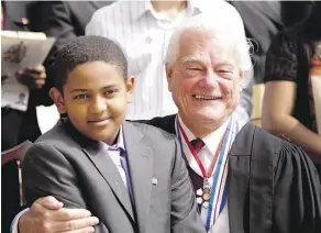  ?? GREG SOUTHAM/FILE ?? Amanual Abitew sits with Senator Tommy Banks for a group photo after a 2012 citizenshi­p ceremony put on by the provincial and federal government­s to celebrate the Queen’s Diamond Jubilee.