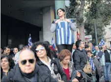  ?? AP PHOTO ?? In this file photo, a woman holds the Greek flag as she gathers with other protesters in a rally to protest a potential Greek compromise in a dispute with neighborin­g Macedonia over the former Yugoslav republic’s official name, in Athens. Activists...