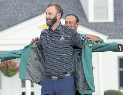  ??  ?? tiger Woods le coloca el saco verde al ganador del Masters de Augusta, Dustin Johnson