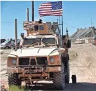  ?? HUSSEIN MALLA/AP ?? A U.S. soldier, left, sits on an armored vehicle behind a sand barrier at a newly installed position in Manbij, northern Syria, in April.