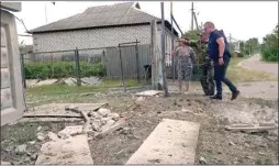  ?? AP PHOTO ?? This image taken from a video shows people indicating a damaged building in the Belgorod region, Russia on Monday.