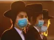  ?? Foto: dpa ?? Ultraortho­doxe Juden mit Gesichtsma­sken bei einer Demo.