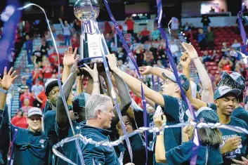  ?? STEVE MARCUS/ASSOCIATED PRESS ?? San Diego State players and coach Brian Dutcher, bottom center, celebrate their victory over Utah State in the Mountain West Tournament championsh­ip game Saturday in Las Vegas, Nevada.