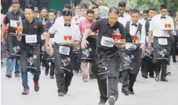  ?? AFPPIX ?? ... Some 300 local and internatio­nal participan­ts from Vietnam, Hong Kong and Thailand joined in the fun at the 5th Internatio­nal Waiters Race held at Ipoh's Kinta Riverfront River Walk in Perak yesterday. State Tourism, Arts and Culture Committee...