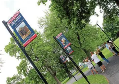  ?? LAUREN HALLIGAN — LHALLIGAN@DIGITALFIR­STMEDIA.COM ?? Family members check out the new Hometown Hero Banners at Veterans Memorial Park in Cohoes during an event on Saturday.