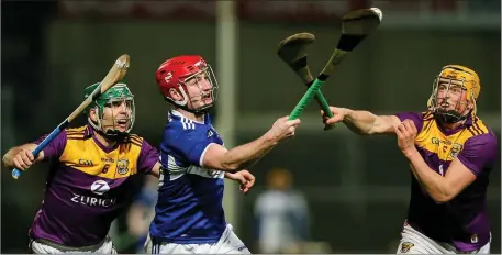  ??  ?? Aaron Bergin of Laois tries to control the ball in spite of heavy pressure exerted by Shaun Murphy and Damien Reck.