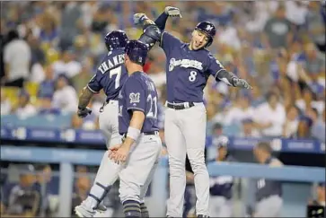  ?? Allen J. Schaben Los Angeles Times ?? ERIC THAMES, left, is congratula­ted by Ryan Braun (8) and Travis Shaw after hitting a two-run home run in the third inning of the Milwaukee Brewers’ 5-2 victory over the Dodgers on July 30 at Dodger Stadium.