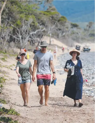  ?? Pictures: STEWART McLEAN ?? SEARCHING: Wangetti Beach residents Jay Sweeney and Carlos Castro and Imogen Collyer from Cairns help comb the area yesterday.