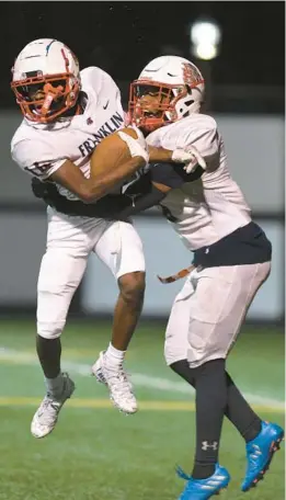  ?? BALTIMORE SUN MEDIA MATT BUTTON/ ?? Franklin teammates Desean Walker, left, and Victor Medina celebrate after Walker’s touchdown during a 17-7 playoff victory over previously unbeaten Bel Air on Friday night.