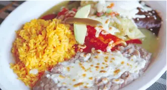  ?? JIM WELLS ?? This trio plate of enchiladas is served with a side of rice and beans, one of many beautifull­y plated and delicious meals available at Tu Tierra Mexican Restaurant.