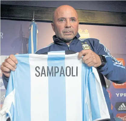  ??  ?? Jorge Sampaoli holds a jersey with his name during his official presentati­on as coach of Argentina.