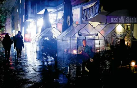  ?? AP ?? Berlin bar patrons sit in plastic tents to separate them from other customers. Coronaviru­s cases are spiking in Germany and other European countries, leading to new curfews and curbs on nightlife and other activities.