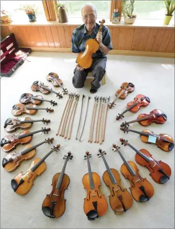  ??  ?? Beamsville’s Bill Marykuca with his collection of violins and handmade bows, most of which he is auctioning off on Saturday.