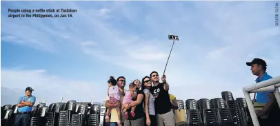  ??  ?? People using a selfie stick at Tacloban airport in the Philippine­s, on Jan 16.
