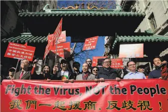  ?? Jessica Christian / The Chronicle ?? Protesters walk through the Dragon Gate in San Francisco’s Chinatown during a February march to protest coronaviru­sfueled racist incidents against Chinese Americans.