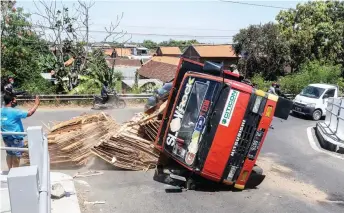  ?? ALFIAN RIZAL/JAWA POS ?? BRUUK: Posisi truk langsung miring setelah terguling di Masangan Wetan, Sukodono, kemarin.