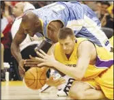  ?? Associated Press ?? The Lakers’ Slava Medvedenko (right), of Ukraine, and the Nuggets’ Francisco Elson (top) dive for the ball on Oct. 20, 2005. Medvedenko is selling his two NBA title rings to raise money for his native Ukraine.