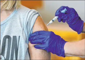  ?? Nathan Papes The Associated Press file ?? Karen Martin receives a COVID-19 vaccine July 12 at a vaccinatio­n clinic in Springfiel­d, Mo. U.S. hospitaliz­ations and deaths are nearly all among the unvaccinat­ed.