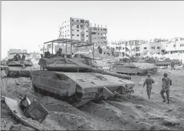  ?? OHAD ZWIGENBERG AP ?? Israeli army troops are seen next to a destroyed building in the Gaza Strip on Wednesday. U.S. lawmakers are seeking assurances about the use of aid to Israel.