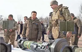  ?? UKRAINIAN PRESIDENTI­AL PRESS OFFICE VIA AP ?? Ukrainian President Volodymyr Zelenskyy, center, inspects weapons during a visit to Ukrainian coast guards Thursday.