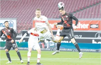  ?? - AFP photo ?? Stuttgart’s defender Waldemar Anton (centre) and Bayern Munich’s forward Robert Lewandowsk­i vie for the ball.