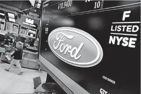  ?? [AP PHOTO] ?? The logo for the Ford Motor Co. appears above a post on the floor of the New York Stock Exchange. Ford said Wednesday it plans to cut 10 percent of its salaried jobs in North America and Asia Pacific this year in an effort to boost profits.
