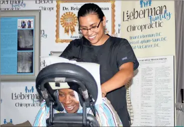  ?? Doug Walker / Rome News-Tribune ?? Sarah Washington (in chair) gets a massage from Amanda Gonzalez of Healing Hands Life Center during the Business Expo.