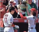  ?? JOHN MCCOY/GETTY IMAGES ?? Los Angeles Angels outfielder Brett Phillips puts a samurai helmet on teammate Shohei Ohtani to celebrate his home run on April 9, 2023, in Anaheim, Calif.