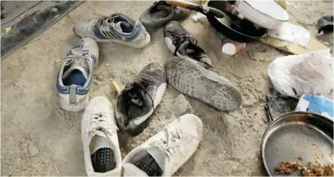  ?? AP ?? Shoes lay abandoned in the entrancewa­y of a tent in the makeshift migrant camp known as ‘the jungle’ near Calais, northern France. —