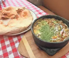  ?? MICHAEL SEARS / MILWAUKEE JOURNAL SENTINEL ?? Fahsah Bits of Meat, a bubbling-hot Yemeni soup, is served at Mendy with clay-oven bread that’s the size of a dinner plate.