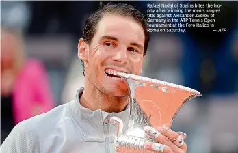  ?? AFP ?? Rafael Nadal of Spains bites the trophy after winning the men’s singles title against Alexander Zverev of Germany in the ATP Tennis Open tournament at the Foro Italico in Rome on Saturday. —