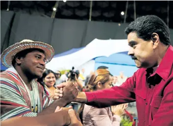  ?? GETTY IMAGES ?? A handout photo released by the Venezuelan presidency shows President Nicolas Maduro, right, being greeted during a meeting with constituti­onalists in Caracas on Wednesday. Maduro postponed the launch of a powerful new constituen­t assembly to Friday in...