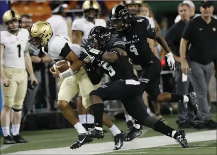  ?? MARCO GARCIA - THE ASSOCIATED PRESS ?? Army quarterbac­k Christian Anderson (13) gets shoved out of bounds by Hawaii defensive back Khoury Bethley (5) during the second half of an NCAA college football game Saturday, Nov. 30, 2019 in Honolulu.