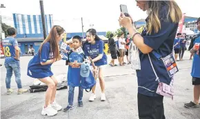  ?? ?? Rabbit Girls interactin­g with a young football fan for social media before BG Pathum United FC ’s Thai League 1 football match against Sukhothai at BG Stadium in Pathum Thani.