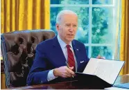  ?? EVAN VUCCI/ASSOCIATED PRESS ?? President Joe Biden signs a series of executive orders concerning health care in the Oval Office at the White House on Thursday.