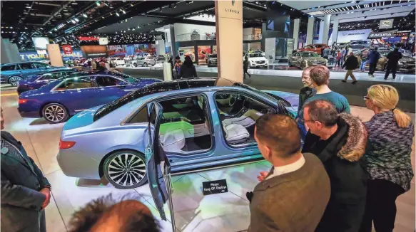  ?? KIMBERLY P. MITCHELL ?? People stop to examine the “suicide doors” on the 2019 Lincoln Continenta­l Coach Edition at the North American Internatio­nal Auto Show in downtown Detroit on Saturday. The limited-edition model is the most expensive Lincoln sold to date.